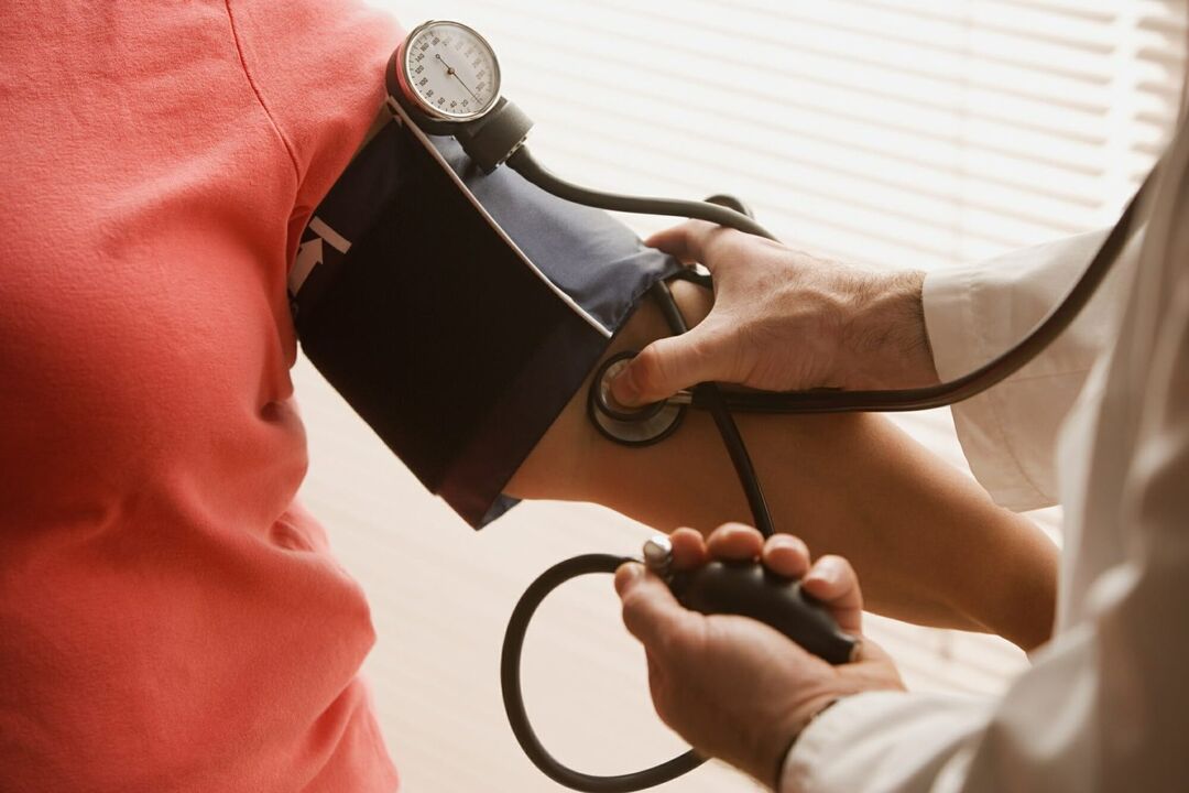 Orvos méri a vérnyomást egy magas vérnyomásban szenvedő betegnél